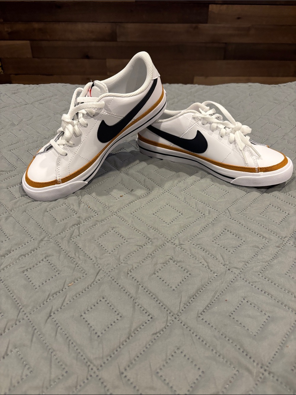 Nike White Low-Top Sneakers with Black Swoosh and Gold Stripe